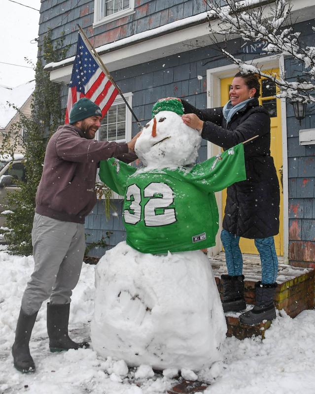 Jason, left, and Katie Bragg repair the head of their Union Street Eagles snowman after someone, maybe a Cowboys fan, knocked it off. DAN COOK PHOTO