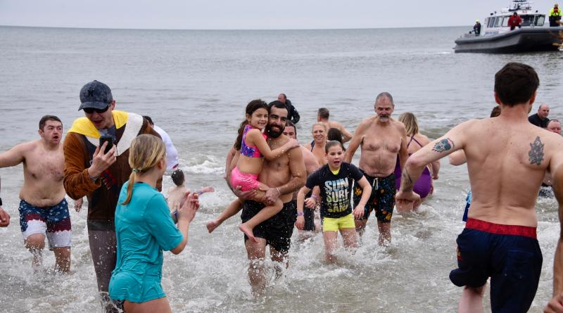 It’s every man, woman and child for themselves as plungers run to escape the cold water. RON MACARTHUR PHOTO