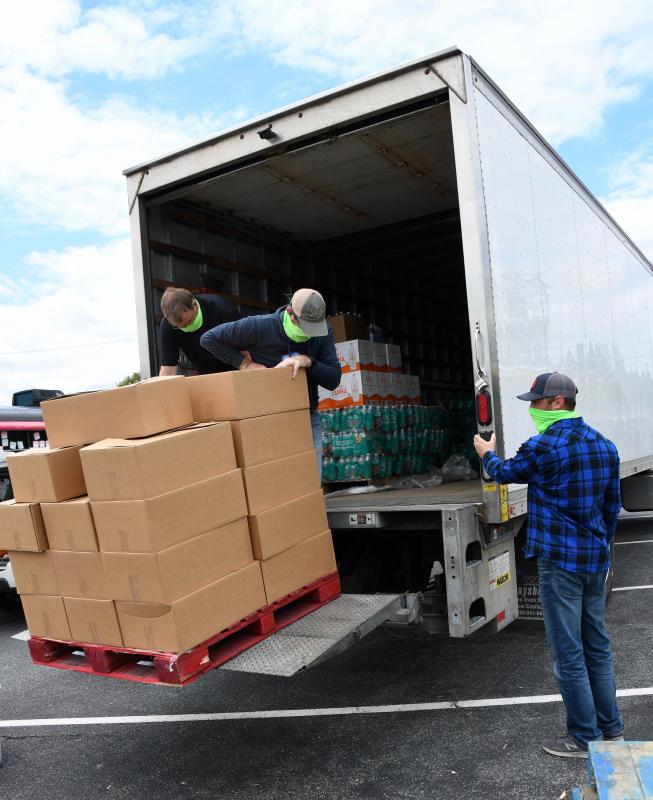 From left, Kirk Hedstrom, Rob Alexander and Joe Yurisic, all Schell Brothers staff, unload a pallet of pre-boxed food for distribution.