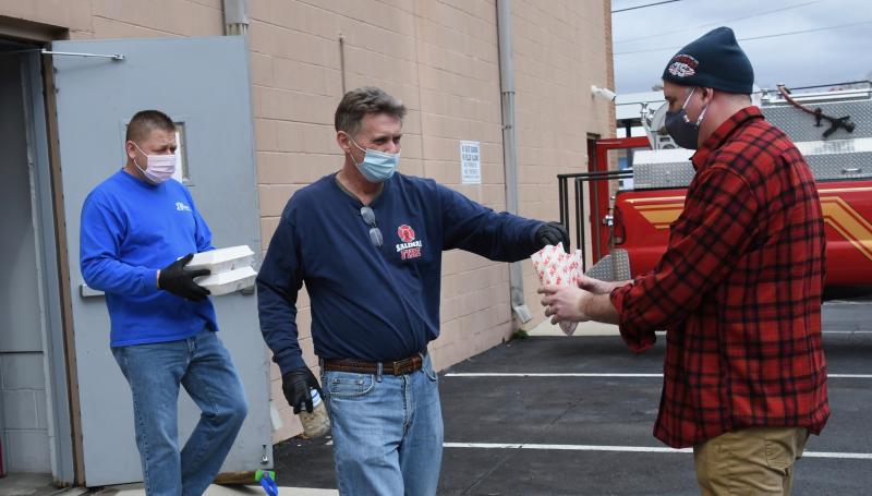 Georgetown Fire Co. volunteers Penuel Barrett, left, and Keith Bryan hand deliver oyster dinners Feb. 27 to Rob Robinson of Georgetown during the fire company’s 84th annual Oyster Eat. The traditional indoor event had to be canceled this year due to COVID-19 restrictions on large gatherings. RON MACARTHUR PHOTOS