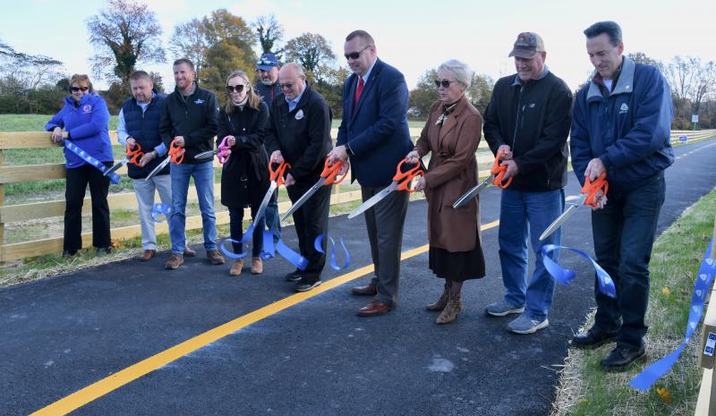 Officials gather to cut a ribbon to open Phase 8 of the Lewes-to-Georgetown Trail. Taking part are (l-r) Kathryn Beasley, DelDOT public relations; Penuel Barrett, Georgetown Town Council; Lance Mears, Georgetown Little League president; Nicole Majeski, DelDOT secretary; Anthony Aglio, DelDOT bicycle coordinator; Georgetown Mayor Bill West; Sen. Brian Pettyjohn, R-Georgetown; Rep. Ruth Briggs King, R-Georgetown; Jeff Niezgoda, DelDOT engineer; and Brad Saborio, DelDOT supervisor.