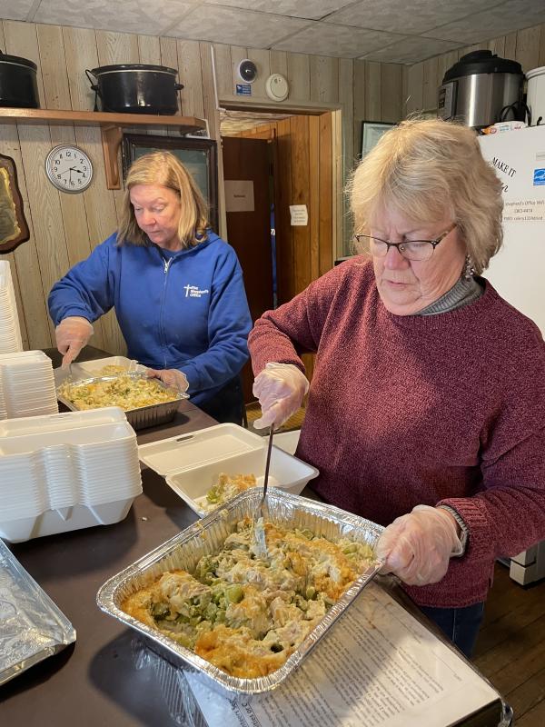 Coastal Club residents Nancy Conway, left, and Anne Marie Kujawski prepare to serve dinner. A group of residents volunteers to provide dinner the second and fourth Tuesdays of each month. About 200 people are fed each day.