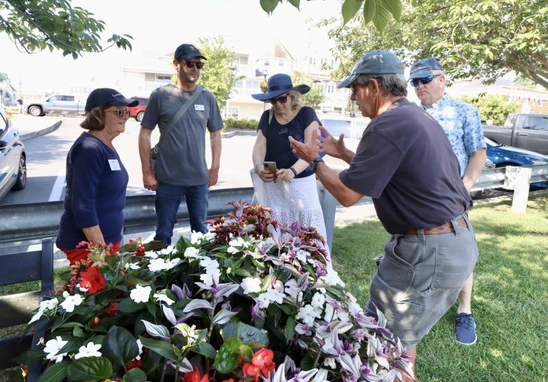Lewes in Bloom volunteer Bill Adelman, right, talks about the flowers in 1812 Park. Shown are (l-r) Cindy DeEmedio, Lewes in Bloom volunteer; Alain Cappelle; Andrea Bocsi; and Ed Zygmonski, Lewes in Bloom board co-chair.