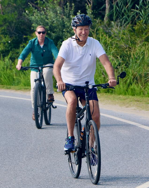 President Joe Biden at the start of his bike ride on the Gordons Pond Trail Aug. 11. The president rode solo, surrounded by Secret Service agents.