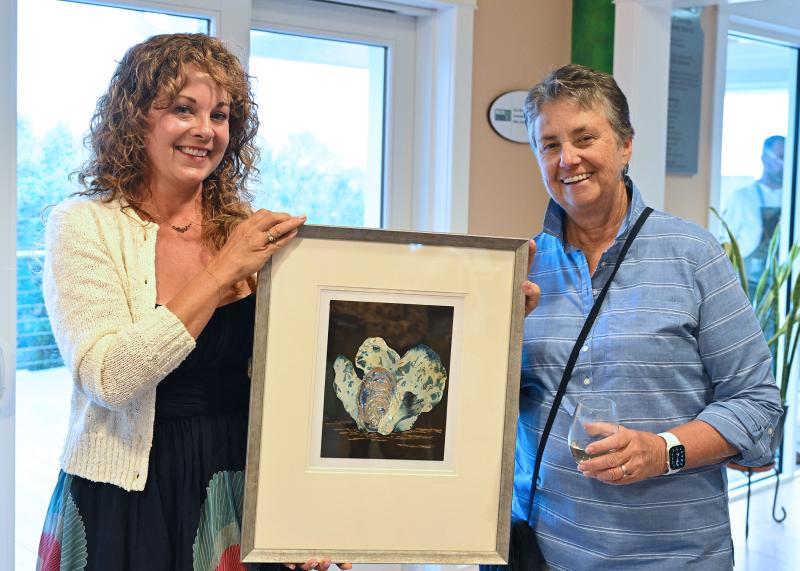 Sherry Insley, the photographer of “Blue Hens,” presents the photo to Sandy Neverett of Rehoboth Beach.