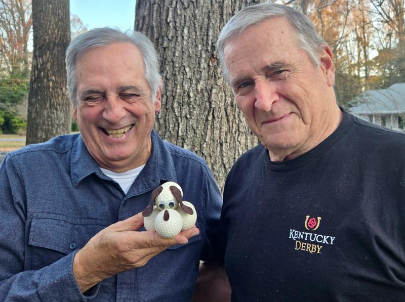 Kevin McTigue of Angola by the Bay, right, is a good friend, avid golfer, and equally avid thrift store shopper who considers my annual Don’t Buy Me This Golf Stuff column as a personal challenge to ignore completely. He recently presented me with a Golf Ball Dog, a craft project made with seven used golf balls and some felt fabric for the ears and nose. SUE SCHRANCK PHOTO