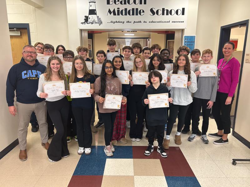 Gathered to celebrate Beacon eighth-graders’ success in the Young Writers USA creative writing contest are in back (l-r) Jamison Dalton, Jameson Turchin, Adryana Savage, Brandt Kuklish, Jameson MacPhee, Liam Passo, Vinny Gilbert, Wyatt Timmons, Brennan Dalecki, Asher Richards, Ke’Jon Bland, Cole Goodsell and Sean Morgan. In the middle are teacher Christopher Maddox, Riley Furr, Aalya Desai, Mackenzie Mears, Simran Van Scoyoc, Rylie Lewis, Charlie Phoebus and teacher Kelly Slavoski. In front are Taylor Day, Marley Daugherty, Jill Vyas and Greyson Linton. Not pictured are John Doerfler, Mags Bourne, Killian Allmon, Avery Fay and Erica Hippolyte. SUBMITTED PHOTO